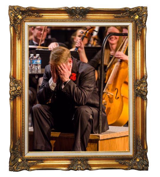 Conductor sitting in front of orchestra in gold frame